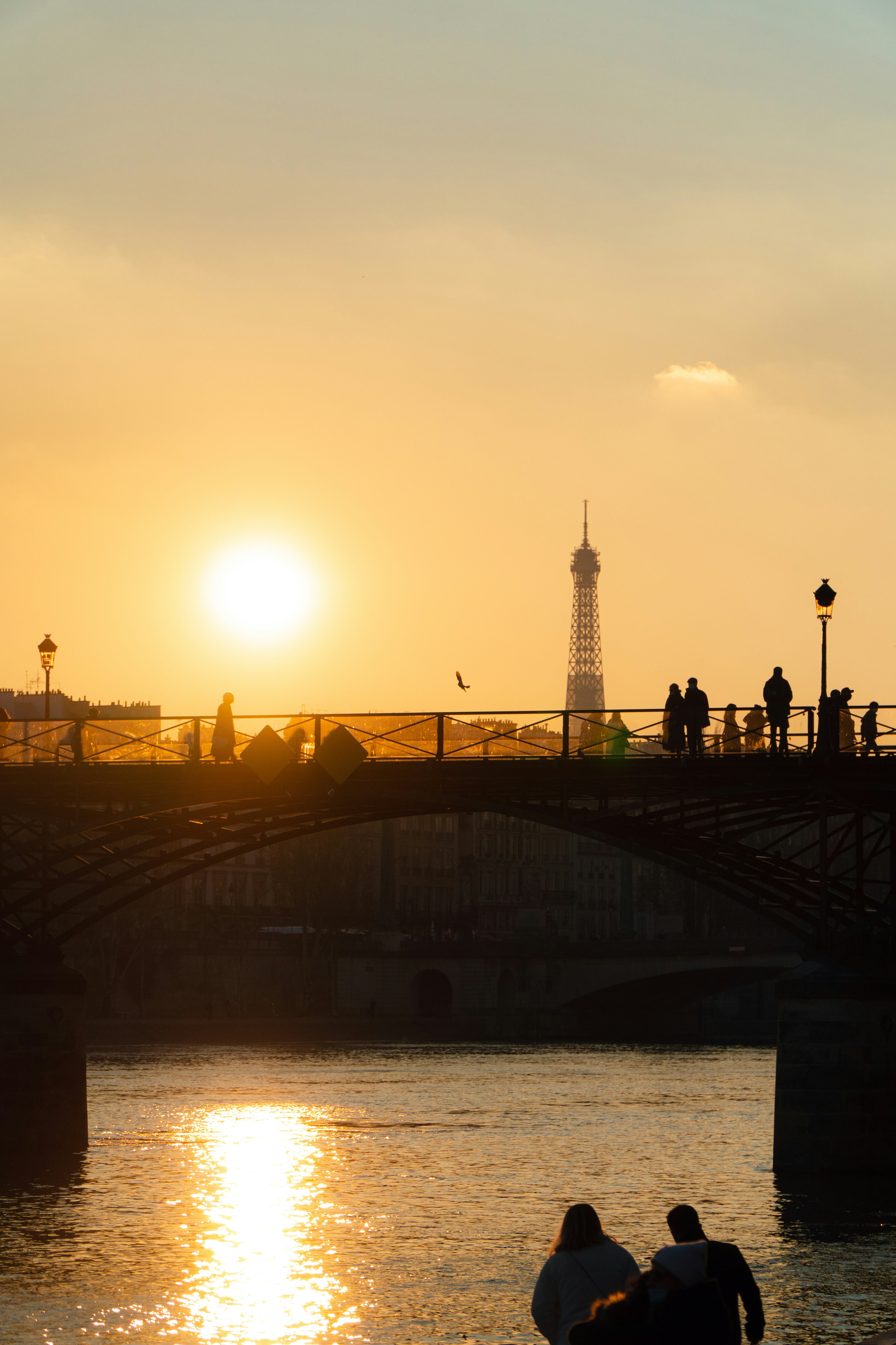 silhouette of people walking on bridge during sunset